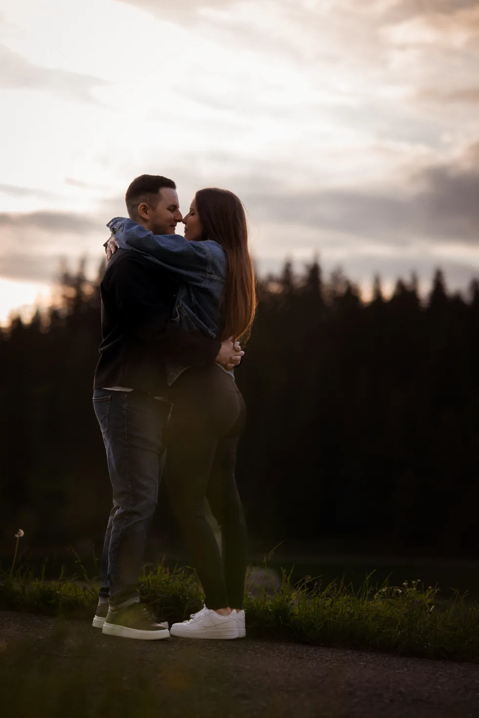 Paar im Abendlicht vor Wald und See – Modefotografie im Gegenlicht